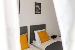 Bett mit orangefarbenen und weißen Kissen in einem Zimmer in der Unterkunft VILLA TO-TU in Szklarska Poręba