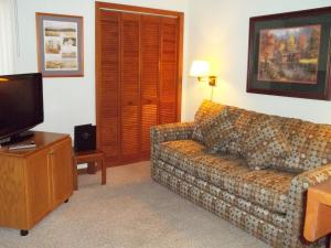a living room with a couch and a tv at Fairways of the Mountain, a VRI resort in Lake Lure