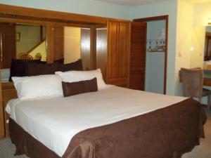 a bedroom with a large white bed with a mirror at Fairways of the Mountain, a VRI resort in Lake Lure