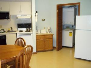 a kitchen with a table and a white refrigerator at Fairways of the Mountain in Lake Lure +5 photos
