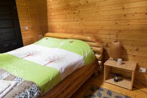 a bedroom with a bed in a log cabin at Cuibul Vulturilor - Casuta in Copac in Moisei