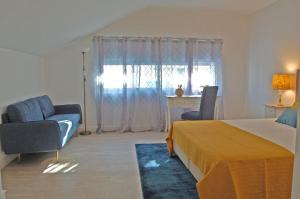 a bedroom with a bed and two chairs and a window at Atlantic Town 2 - Free Parking in Ponta Delgada