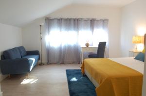 a bedroom with a bed and two chairs and a window at Atlantic Town 2 - Free Parking in Ponta Delgada