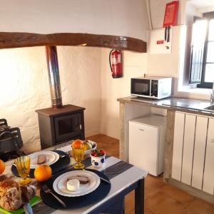 a kitchen with a table with food and a stove at Suão Retiro Alentejano in Amieira