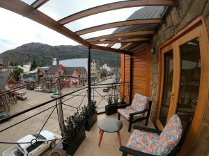 a balcony with two chairs and a view of a town at Departamentos - Belgrano 810 in San Martín de los Andes +31 photos