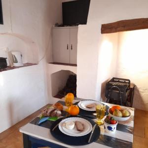 eine Küche mit einem Tisch und Teller mit Lebensmitteln darauf in der Unterkunft Suão Retiro Alentejano in Amieira