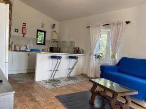 a living room with a blue couch and a kitchen at Casa do Milho in Carvoeiro