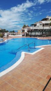 a large swimming pool with blue water and buildings at Los Geranios, Close to BEACH, Puerto Colon, YellowCat 2 in Adeje