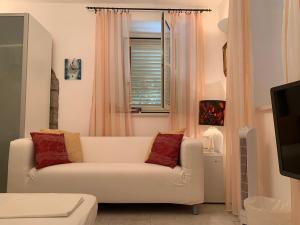 a living room with a white couch and a window at Guesthouse Villa Colenda in Korčula