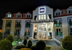 a large white building with a neon sign on it at Great Polonia Ustka in Ustka