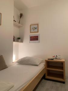a bedroom with a bed and a wooden night stand at Guesthouse Villa Colenda in Korčula