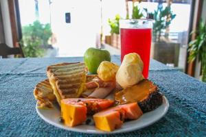 a plate of food on a table with a drink at Pousada Coração da Ilha do Mel in Ilha do Mel