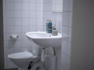 a white bathroom with a sink and a toilet at Hotel Lemonade in Gothenburg
