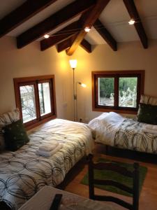 a bedroom with two beds and two windows at Allotjaments Serra de Tramuntana in Valldemossa