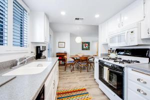a kitchen with white cabinets and a dining room at Mountain View Modern Condo Permit# 4340 in Palm Springs