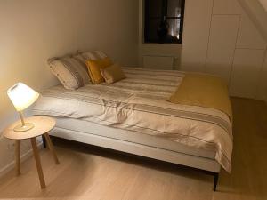 a bed in a bedroom with a table and a lamp at Les Cigognes in Knokke