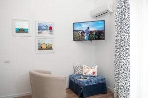 een kamer met een stoel en foto's aan de muur bij Blue Sea House in Cefalù