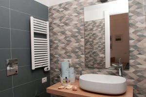 een badkamer met een witte wastafel en een spiegel bij Blue Sea House in Cefalù