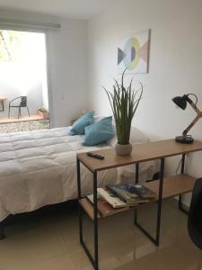 ein Schlafzimmer mit einem Bett und einem Tisch mit einer Pflanze darauf in der Unterkunft Penguins Flats 4 in Ushuaia
