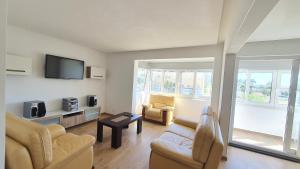 a living room with two chairs and a tv at A Casa do Parque in Santo André