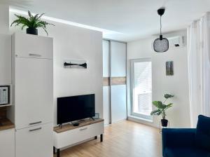 a living room with a flat screen tv on a white wall at BeTree in Bratislava