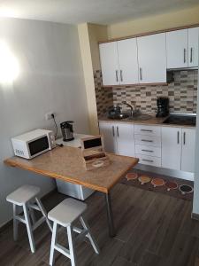a kitchen with a table with a microwave and chairs at Vistas al Mar in Tacoronte