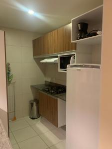 eine kleine Küche mit einem Kühlschrank und einer Mikrowelle in der Unterkunft VG SUN CUMBUCO C5 - apto 209 in Cumbuco