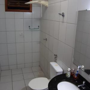 ein weißes Bad mit einem WC und einem Waschbecken in der Unterkunft Residencial Gaivotas 40m da praia Nova vicosa in Nova Viçosa