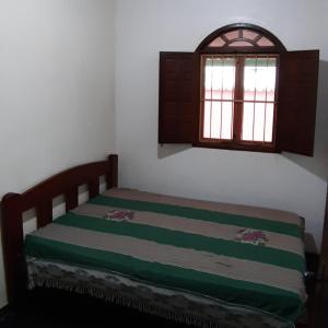 ein kleines Schlafzimmer mit einem Bett und einem Fenster in der Unterkunft Residencial Gaivotas 40m da praia Nova vicosa in Nova Viçosa