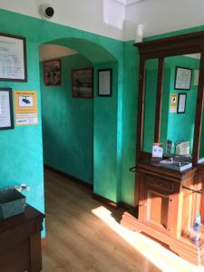 Zimmer mit einer grünen Wand und einem Holztisch in der Unterkunft Hostal La Concha in Somo