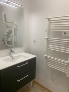 une salle de bain avec un lavabo et un miroir dans l'établissement L’Estable du Pin, à Le Pin