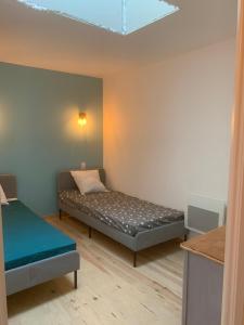 Cette petite chambre comprend un lit et un plafond. dans l'établissement L’Estable du Pin, à Le Pin