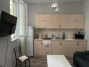 a kitchen with a table and a tv in a room at Batumi Summer Hotel in Batumi