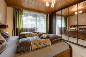 2 Betten in einem Zimmer mit großem Spiegel in der Unterkunft Gästehaus Friedlich in Schönau am Königssee