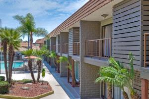 a building with palm trees and a swimming pool at Best Western Oceanside Inn in Oceanside