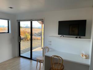 a living room with a television and a table with chairs at Mt Barker in Wanaka