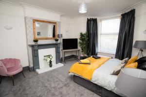 a bedroom with a bed and a fireplace and a television at South Cheshire House in Wistaston