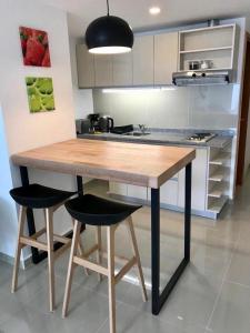 uma cozinha com uma mesa de madeira e 2 bancos em Penguins Flats 5 em Ushuaia