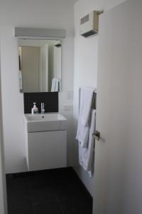 a white bathroom with a sink and a mirror at Mt Barker in Wanaka