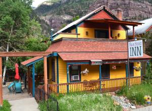 a yellow house with a sign that says minnesota inn at The Ouray Main Street Inn in Ouray