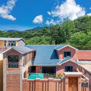 a brick house with a blue roof at Beijing Mutianyu Great Wall Wangshanyuan Homestay in Huairou