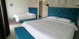 een slaapkamer met 2 bedden en een blauw hoofdeinde bij Hotel Arenal Vista Lodge in Fortuna