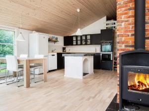 cocina y sala de estar con chimenea en 6 person holiday home in Idestrup, en Bøtø By