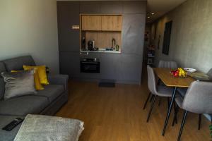 ein Wohnzimmer mit einem Sofa und einem Tisch sowie eine Küche in der Unterkunft Sal, Terra e Mar in Aveiro
