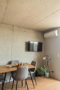 ein Esszimmer mit einem Tisch und einem TV an der Wand in der Unterkunft Sal, Terra e Mar in Aveiro