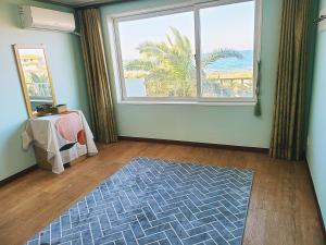 a living room with a large window and a rug at Villae Resort in Jeju