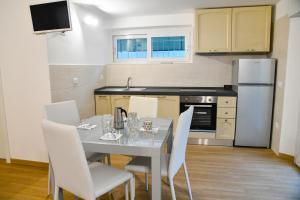 a kitchen with a table with white chairs and a refrigerator at Luna di Cittá in Fano