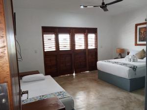a bedroom with a bed and a window at Hotel Maria Maria in Bacalar