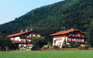 un par de edificios frente a una montaña en Gästehaus Koyerbauer Boardinghouse en Aschau im Chiemgau