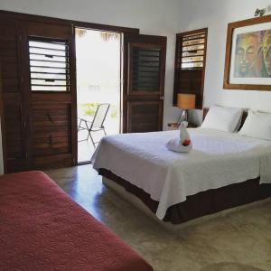 a bedroom with a bed with a bird sitting on it at Hotel Maria Maria in Bacalar